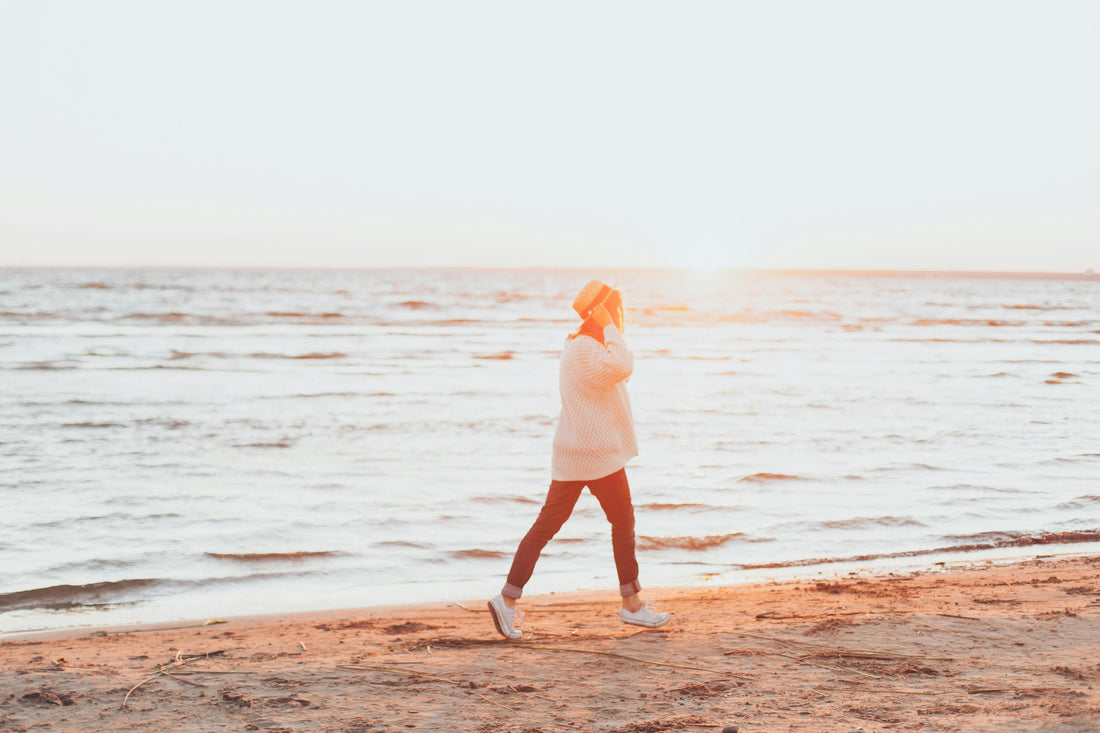 Person walking on the beach for blog about finding a healthy exercise routine