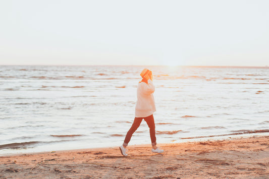 Person walking on the beach for blog about finding a healthy exercise routine